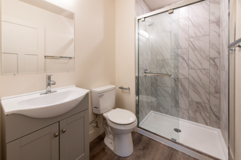 A white toilet sits next to a sink in a bathroom.
